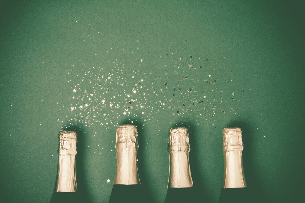 Bottles Of Champagne With Gold Glitter And Space For Text On Gre